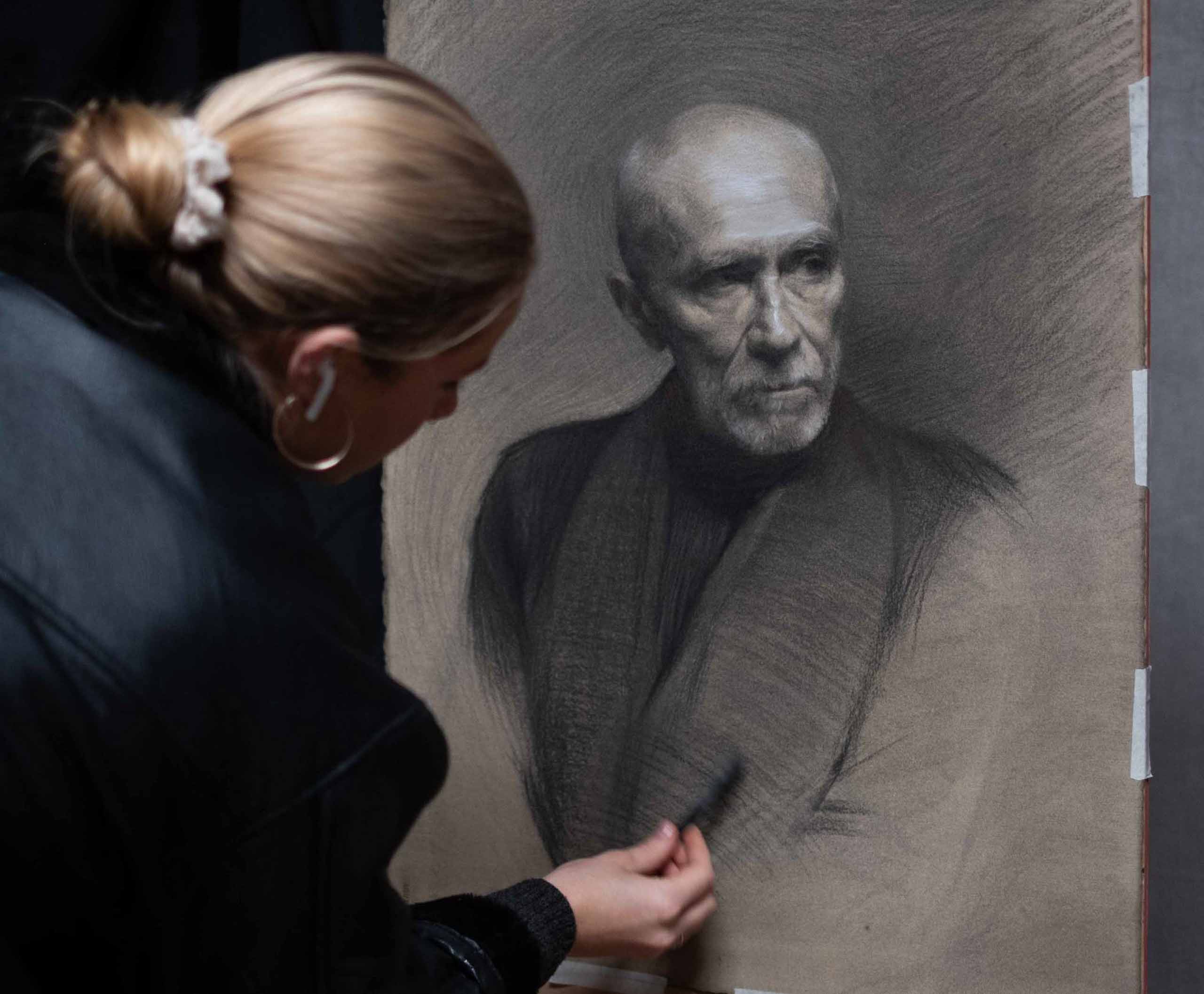 Intermediate Painting Student Nova Crowder at work on a charcoal portrait drawing from life_